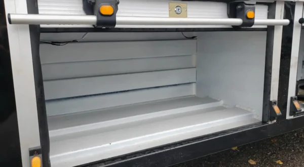 Metro FB-10 flatbed tow truck under-body aluminum tool storage cabinet open view