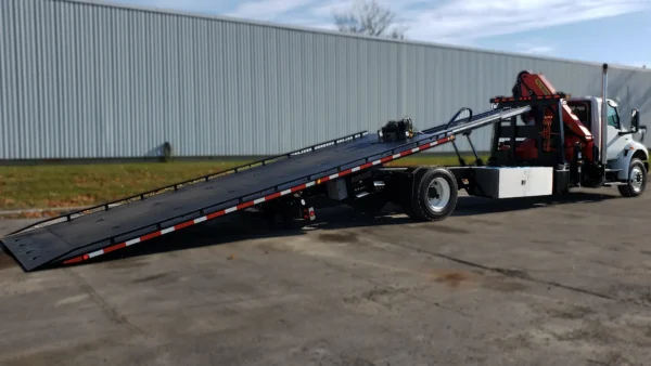 Metro FB-15 flatbed recovery truck with slide-out hydraulic deck extended for loading