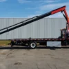 Metro FB-15 flatbed tow truck with knuckle boom crane fully extended along the deck