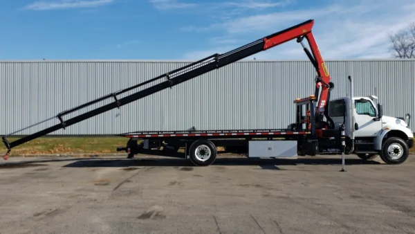 Metro FB-15 flatbed tow truck with knuckle boom crane fully extended along the deck