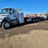 Metro FB-15 heavy-duty flatbed tow truck long-wheelbase chassis in industrial yard