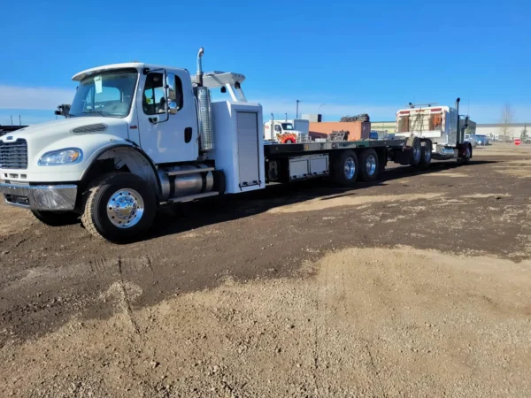 Metro FB-15 heavy-duty flatbed tow truck long-wheelbase chassis in industrial yard