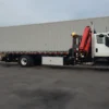 Metro FB-15 flatbed tow truck using wheel lift to tow a white sedan