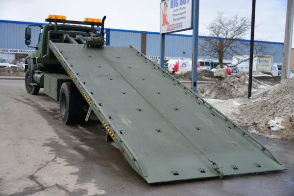 Metro FB-15 tilt-deck recovery truck with hydraulic slide bed deployed on snowy ground