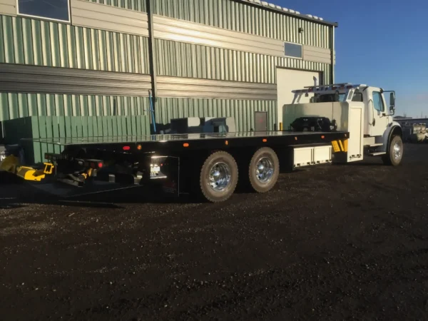 Metro FB-15 flatbed tow truck side view with long wheelbase and dual rear axles