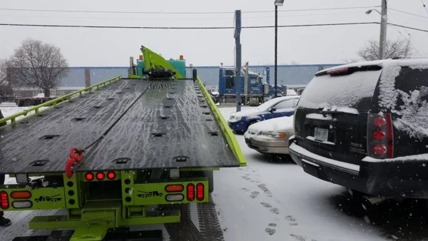 Metro FB-20 heavy-duty flatbed tow truck with extended steel deck in snowy yard