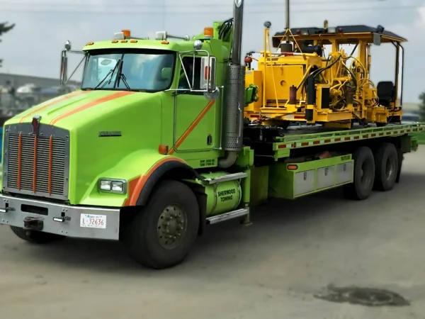 Metro FB-20 hauling a yellow industrial machine on a construction site