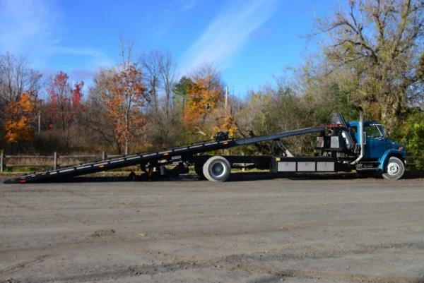 Metro FB-20 extended flatbed deck tilted for loading in outdoor yard