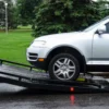 Metro Flatbed FB-5 loading a passenger vehicle onto the tilt deck during roadside recovery