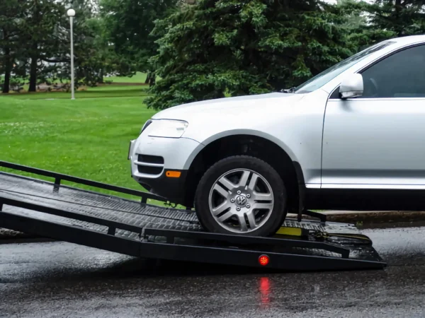 Metro Flatbed FB-5 loading a passenger vehicle onto the tilt deck during roadside recovery