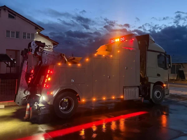 Metro Tow Trucks INT-16 heavy-duty integrated wrecker rear view at night with illuminated safety lights