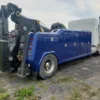 Metro Tow Trucks INT-16 blue heavy-duty integrated wrecker rear side view on gravel industrial lot