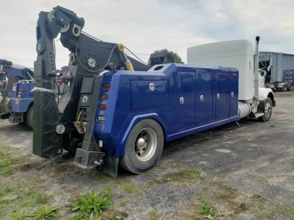Metro Tow Trucks INT-16 blue heavy-duty integrated wrecker rear side view on gravel industrial lot