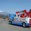 Metro Tow Trucks INT-16 white and blue heavy-duty integrated wrecker left side view with red boom in front of Mt. Fuji