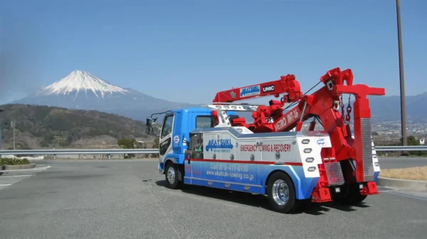 Metro Tow Trucks INT-16 white and blue heavy-duty integrated wrecker left side view with red boom in front of Mt. Fuji