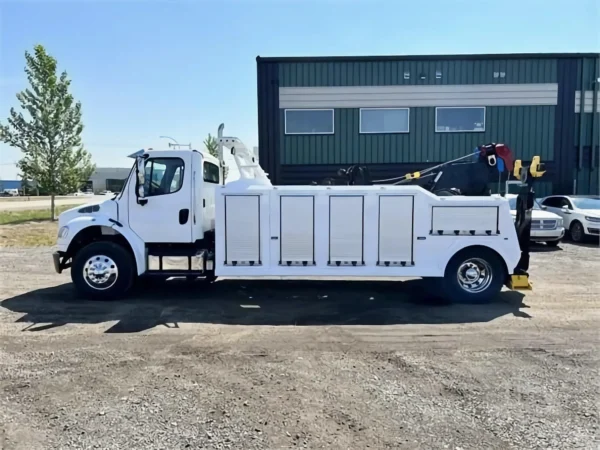 Metro Tow Trucks INT-16 white heavy-duty integrated wrecker left side view parked in front of industrial building