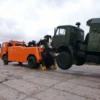 Metro Tow Trucks INT-16 orange heavy-duty tow truck lifting military truck during recovery demonstration