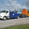 Metro Tow Trucks INT-16 blue and white heavy-duty integrated wrecker towing orange truck on roadside