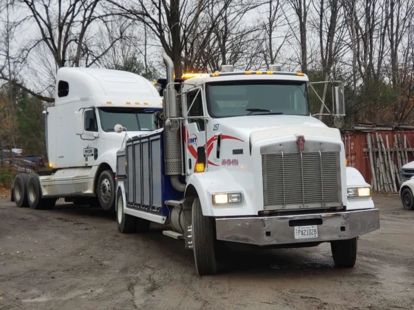 Metro Tow Trucks INT-16 white heavy-duty integrated wrecker front angled view towing white semi-truck