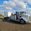 Metro Tow Trucks INT-16 white heavy-duty integrated wrecker towing white box truck on dirt road