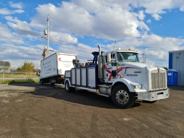 Metro Tow Trucks INT-16 white heavy-duty integrated wrecker towing white box truck on dirt road