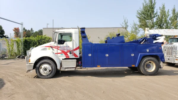 Metro Tow Trucks INT-16 white and blue heavy-duty integrated wrecker left side profile on dirt surface