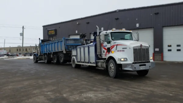 Metro Tow Trucks INT-16 white heavy-duty integrated wrecker towing heavy dump truck at customer site