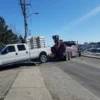 INT-35 wrecker performing roadside towing recovery of a white pickup truck in urban area