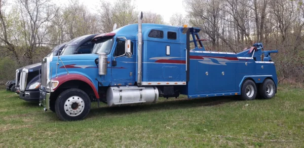Blue INT-35 integrated wrecker parked on grass displaying body and boom