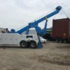 INT-35 heavy wrecker using boom and winch to lift shipping container in industrial recovery operation