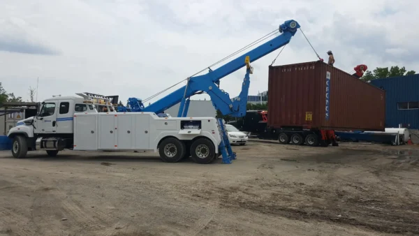 INT-35 heavy wrecker using boom and winch to lift shipping container in industrial recovery operation