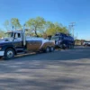 INT-35 heavy-duty integrated wrecker towing a tank truck on a public roadway in sunny conditions