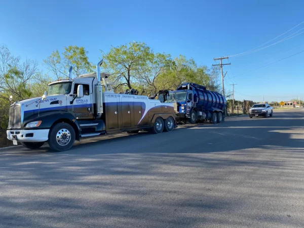 INT-35 heavy-duty integrated wrecker towing a tank truck on a public roadway in sunny conditions