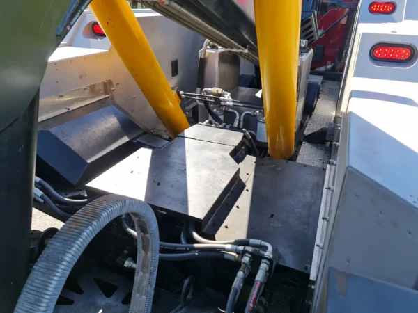 Hydraulic cylinders and structural components of INT-35 underlift assembly with hoses and fittings visible