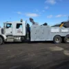 Grey INT-35 integrated wrecker with dual winches and heavy recovery boom parked in industrial area