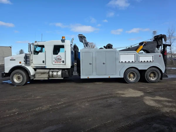 Grey INT-35 integrated wrecker with dual winches and heavy recovery boom parked in industrial area