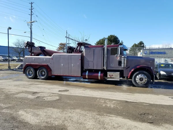 Maroon INT-35 integrated wrecker with heavy-duty underlift and rear recovery boom parked outdoors