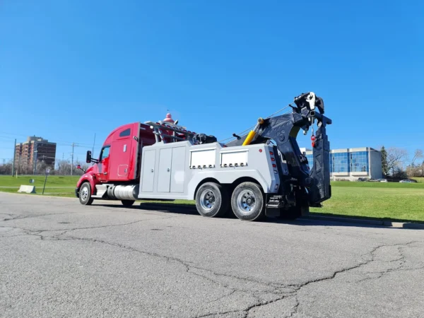 Red and gray INT-35 integrated wrecker extending boom during roadside recovery operation