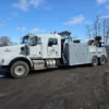 Grey INT-35 heavy-duty integrated wrecker with recovery boom stowed, parked in industrial yard
