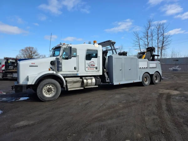 Grey INT-35 heavy-duty integrated wrecker with recovery boom stowed, parked in industrial yard