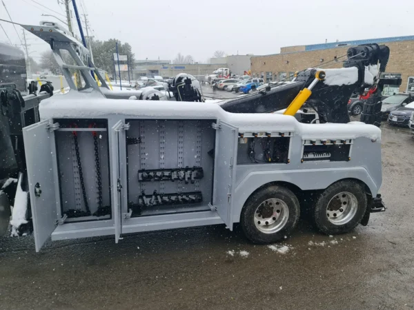 Int-35 integrated wrecker with open equipment storage cabinets showing hydraulic and recovery components