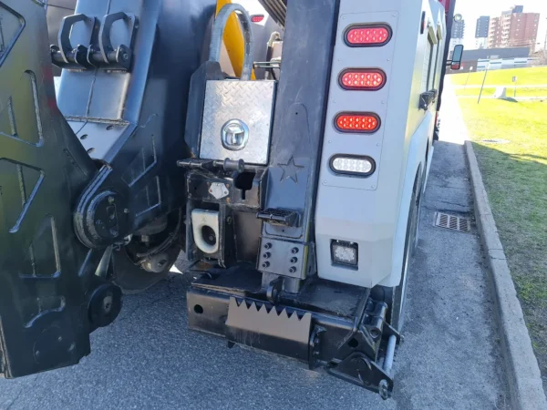 INT-35 wrecker underlift head and towing forks positioned near curbside during recovery setup