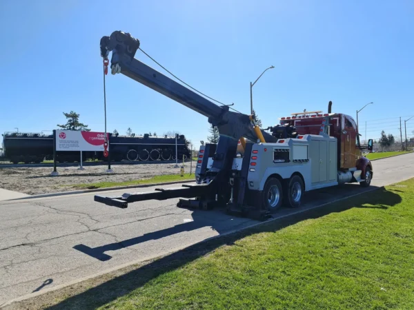 INT-35 integrated wrecker deploying extended boom on roadside grass area