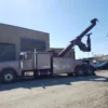INT-35 heavy-duty integrated wrecker with extended recovery boom parked beside industrial building