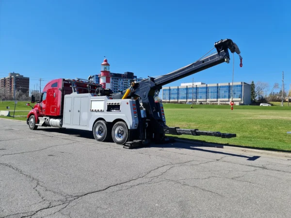 Red and gray INT-35 integrated wrecker extending boom during recovery demonstration on open roadway