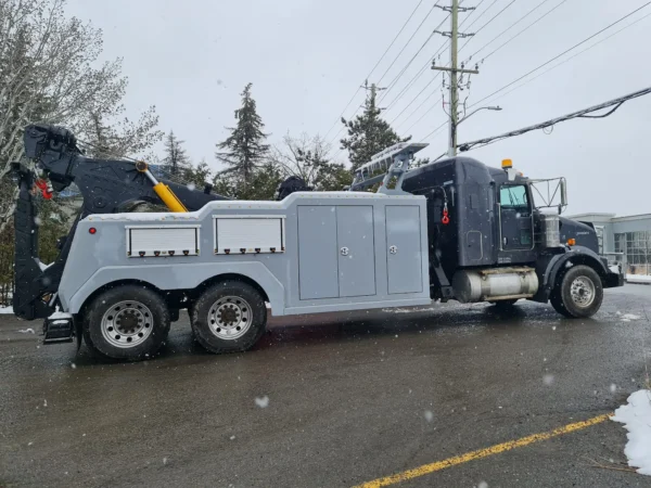 NT-35 wrecker with hydraulic boom preparing for recovery operation on wet pavement