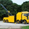 INT-60 heavy duty integrated wrecker in yellow, boom raised for highway towing and recovery operations