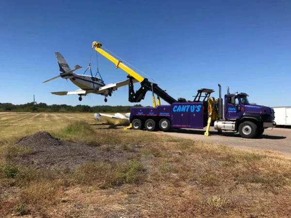 INT-60 integrated wrecker performing aircraft recovery with extended boom and stabilizers deployed on site