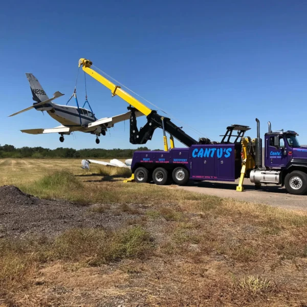 INT-60 integrated wrecker performing aircraft recovery with extended boom and stabilizers deployed on site