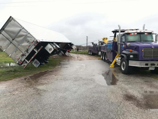 INT-60 heavy wrecker recovering overturned commercial trailer from roadside ditch